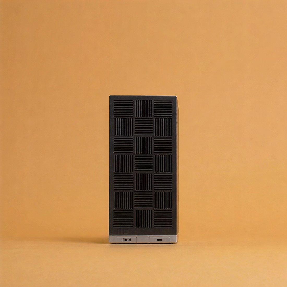 The Box, standing upright on an amber backdrop.